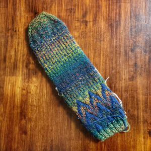 Image of a sock laying flat in navy and multi coloured yarn